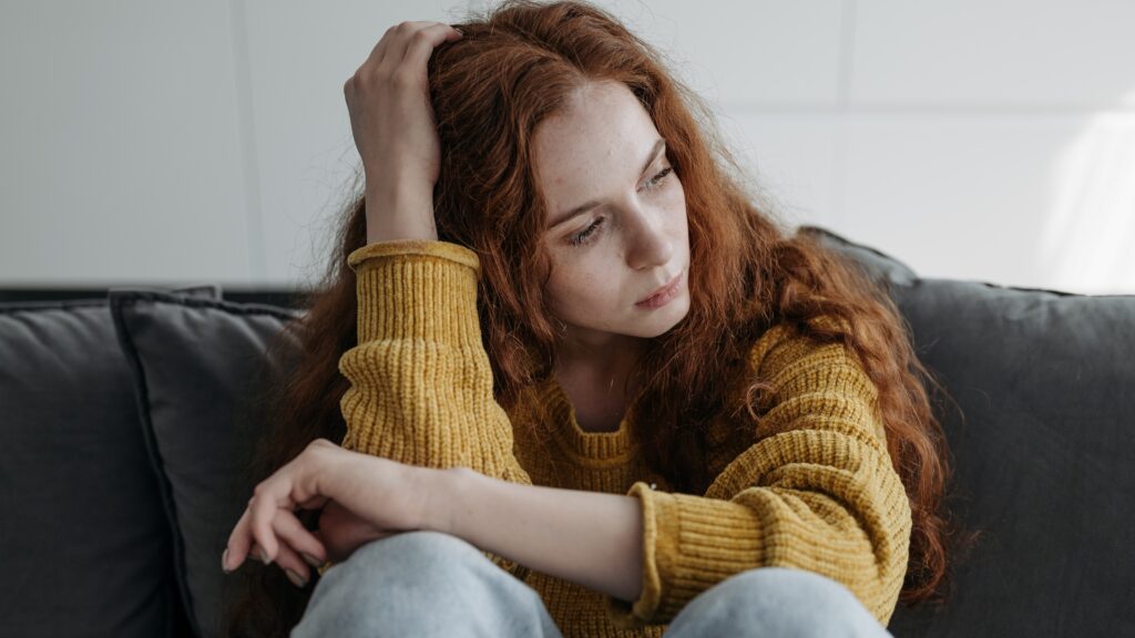 Sad girl sitting on sofa